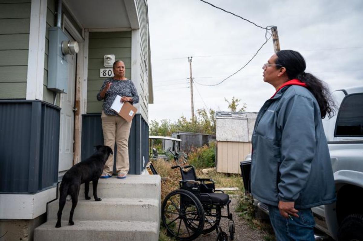 Braving groups of barking dogs outside homes, get-out-the-vote organizer Joyce Tatsey Spoonhunter, left, goes door-to-door registering voters across the Heart Butte community with Red Medicine co-founder Patrick Yawakie-Peltier and other voter organizers on Sept. 20. For years, Native vote organizers have faced numerous barriers such as long travel distances to polls and lack of traditional addresses or mailing services when it comes to registering people to vote and getting voters to the polls. (Antonio Ibarra, Missoulian)