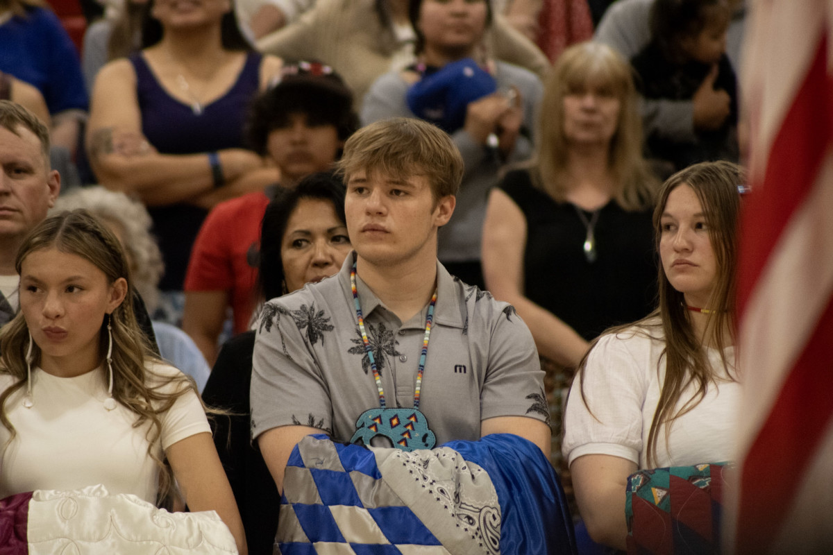 Native graduates listen to speakers during the May 22 feather-tying ceremony at Central High School in Rapid City. (Photo by Amelia Schafer, ICT/Rapid City Journal)