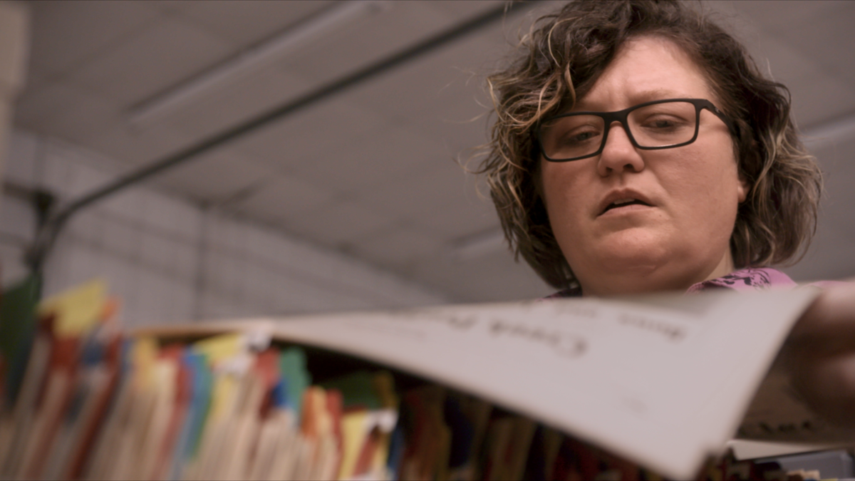 Angel Ellis, Muscogee (Creek), reads a newspaper from the archives of Mvskoke Media in this still image from the documentary "Bad Press." (Photo courtesy of "Bad Press")