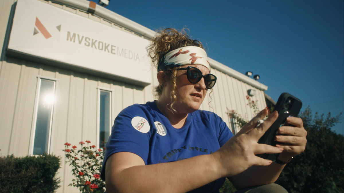 Angel Ellis, Muscogee (Creek), looks at her phone while sitting in front of the Mvskoke Media building in Okmulgee, Oklahoma. (Photo courtesy of "Bad Press")