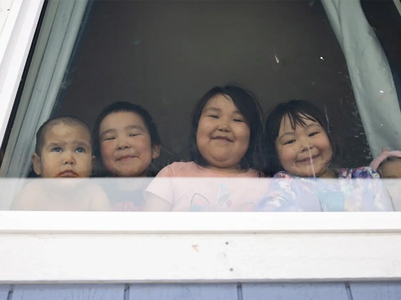 Steven and Lucy Alexie's grandchildren look out the window of their home in Nunapitchuk, Alaska, on April 12, 2025.