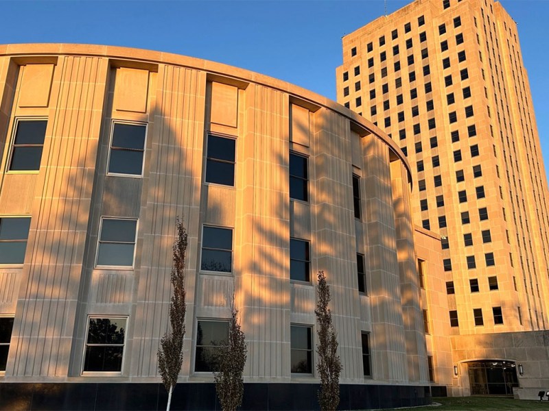 Golden sunlight casts shadows on the exterior of the North Dakota House of Representatives and the Capitol tower in Bismarck on Nov. 10, 2023.