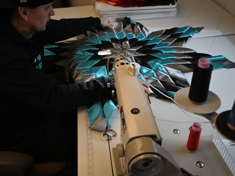 Man sewing Native American Star Quilt