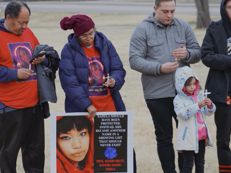 Friends and family of Sahela “Toka Win” Sangrait gather for a vigil to remember the 22 year old, holding candles and posters asking for justice from the Air Force.