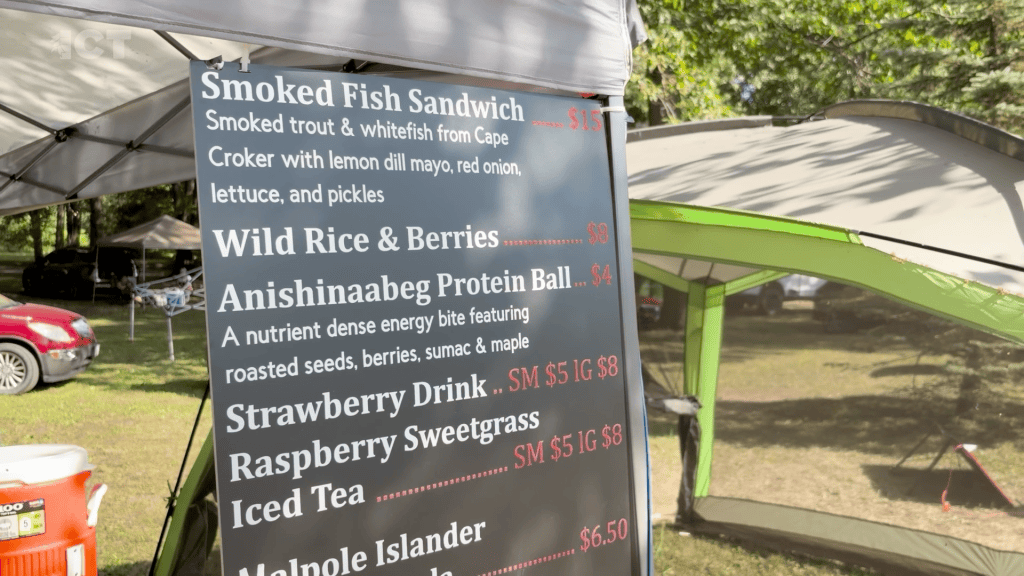Menu for Ode'mini Giizis Cafe ran by Chloe White Deleary at powwow shows Native American food options like smoked fish sandwich, wild rice and berries, anishinaabeg protein balls, rasberry sweetgrass and more