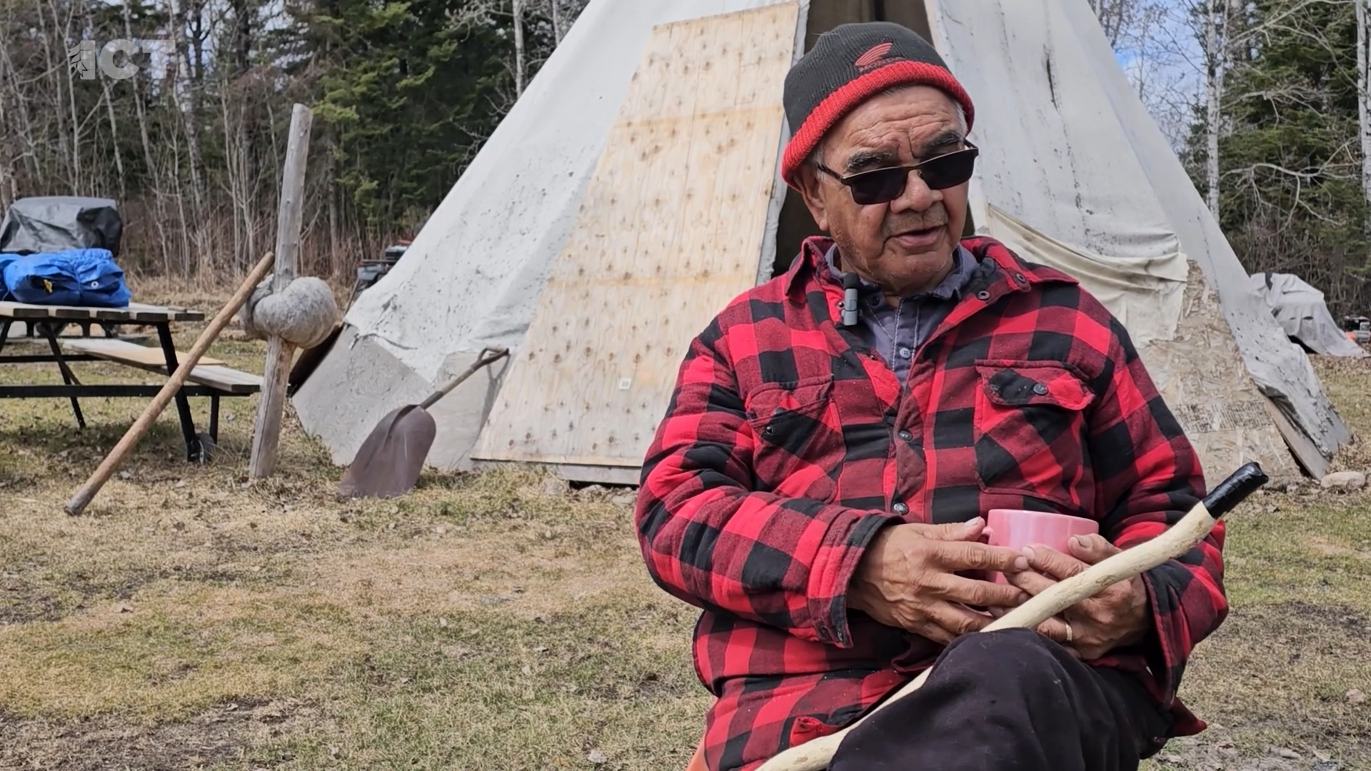 Manigotagan First Nation elder Charles Simard sits in front of teepee