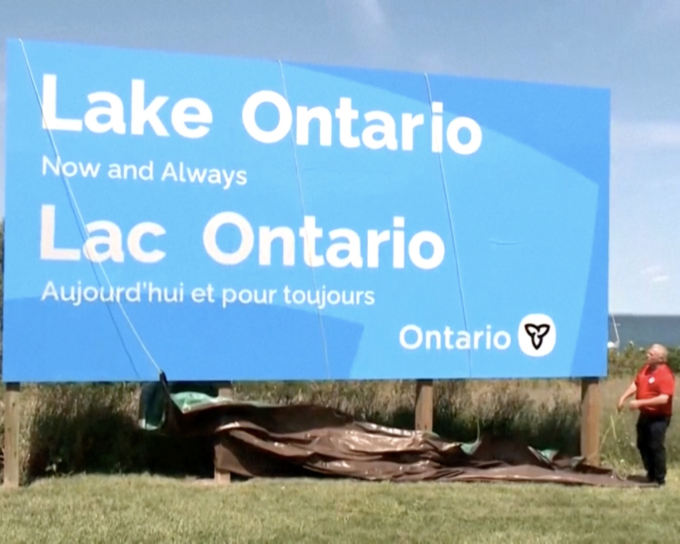 Blue billboard show sign that says 'Lake Ontario now and always' in response to Trumps Lake America