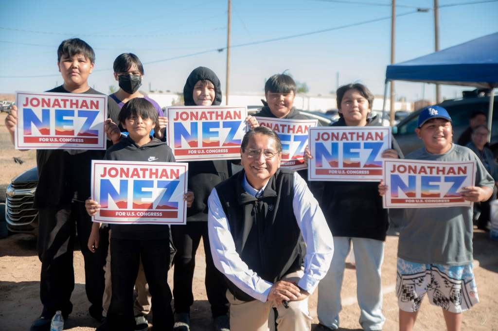 Jonathan Nez poses with children holding his campaign signs during the Central Agency Fair in Chinle, Arizona. (Photo courtesy of Jonathan Nez for Congress)