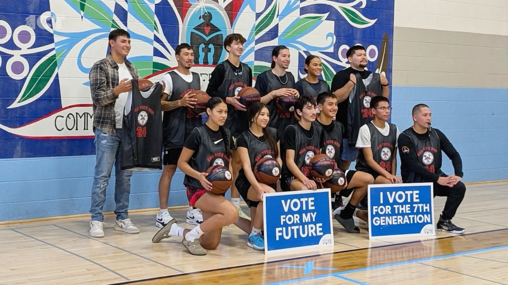 Native American students basketball players with signs vote for my future and I vote for the 7th generation